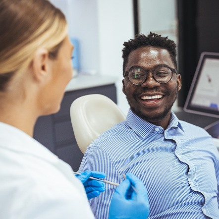Smiling patient talking to dentist in treatment chair