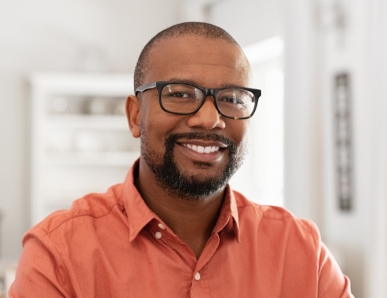 Smiling man in glasses and orange button up shirt