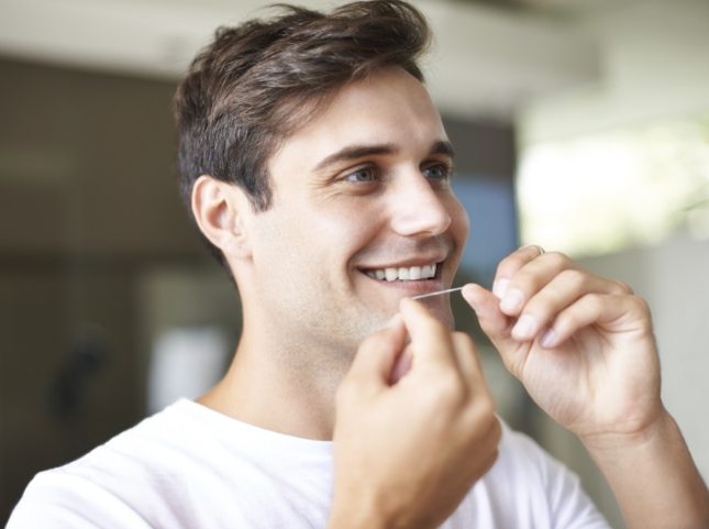 Man flossing his teeth