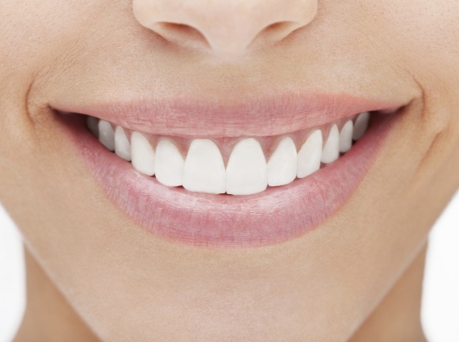 Close up of a person smiling with straight white teeth