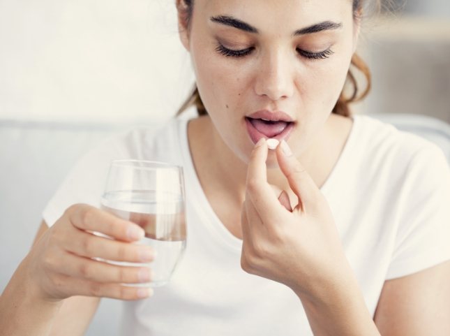 Woman taking a pill for oral conscious sedation dentistry in San Ramon