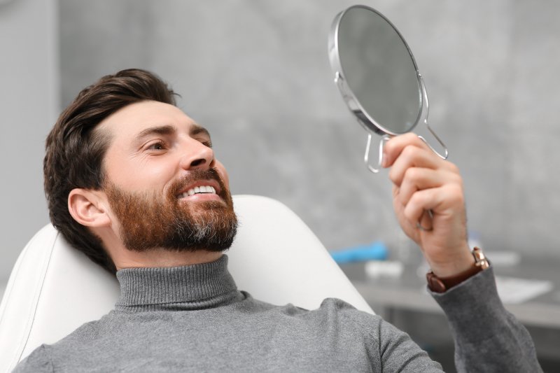 Man smiling at his new cosmetic dentistry treatments