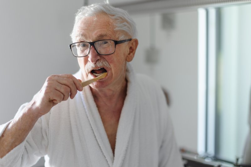 Patient brushing their dentures in their mouth