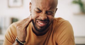 Man clutching jaw in pain. 