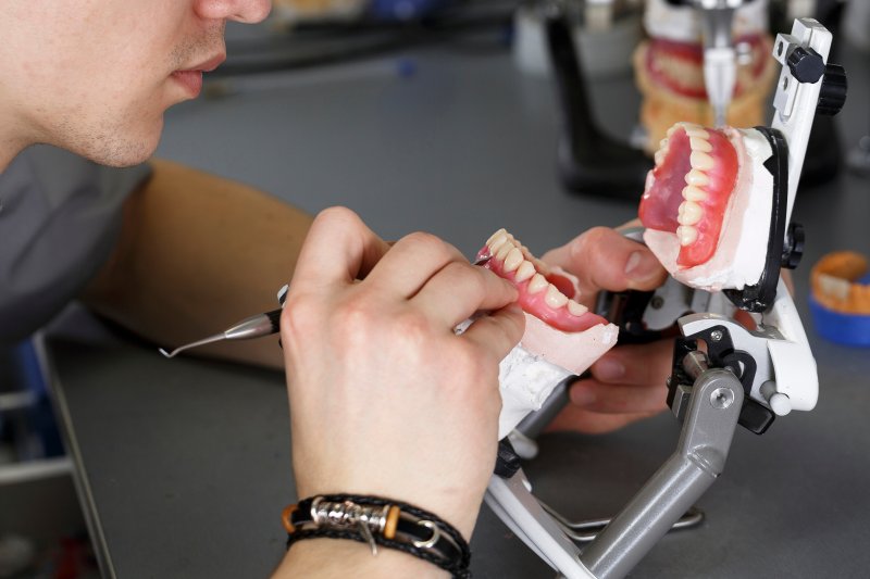 lab technician working on a set of dentures